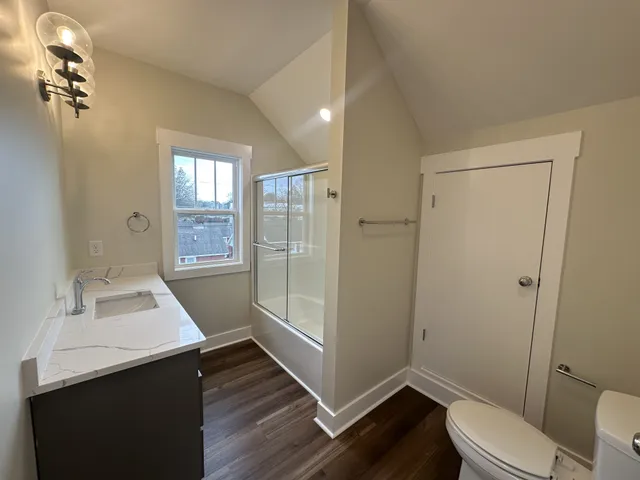 a white toilet sitting next to a bath tub