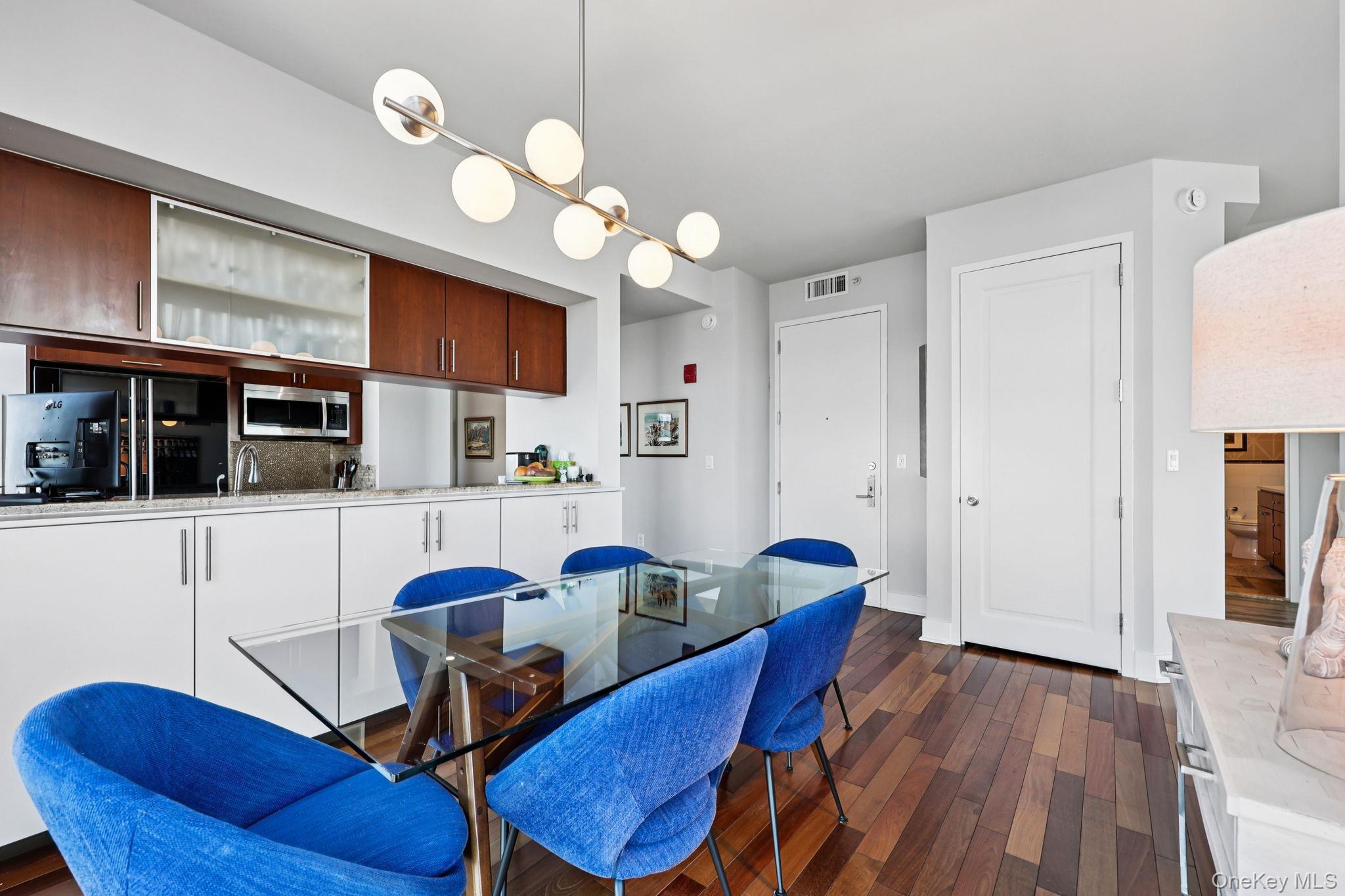 175 Huguenot Street, Unit 2503 New Rochelle, NY 10801 - Photo 13 of 32 a view of a dining room with furniture and wooden floor