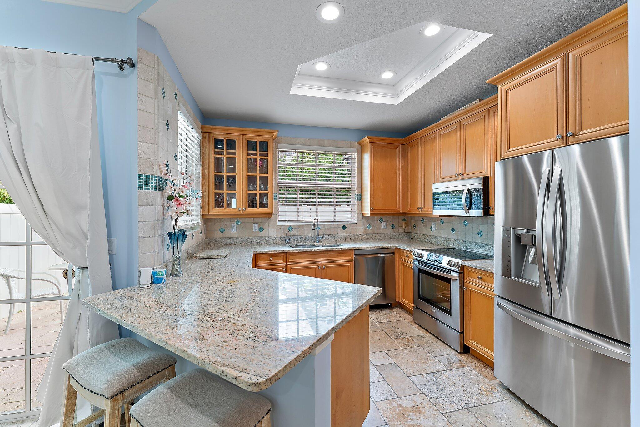 455 Ocean Ridge Way Juno Beach, FL 33408 - Photo 15 of 39 a kitchen with stainless steel appliances granite countertop a refrigerator a stove and a sink