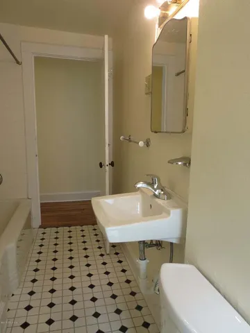 a bathroom with a sink a toilet a mirror and shower