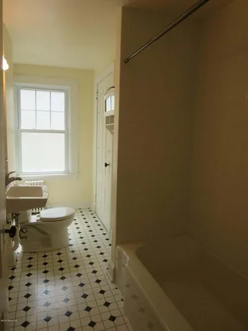 a bathroom with a sink a toilet and a window
