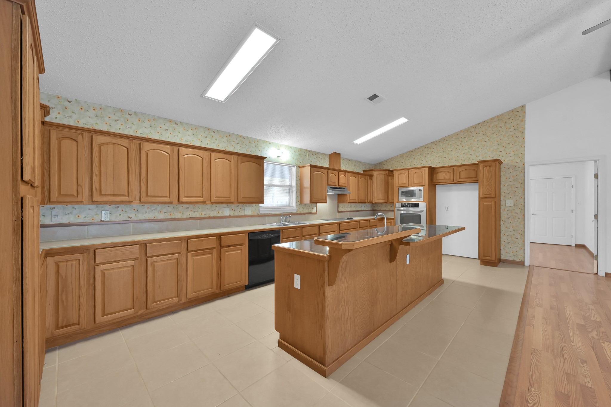 121 Magnolia Boulevard New Caney, TX 77357 - Photo 11 of 39 a large kitchen with kitchen island granite countertop a sink counter space and stainless steel appliances