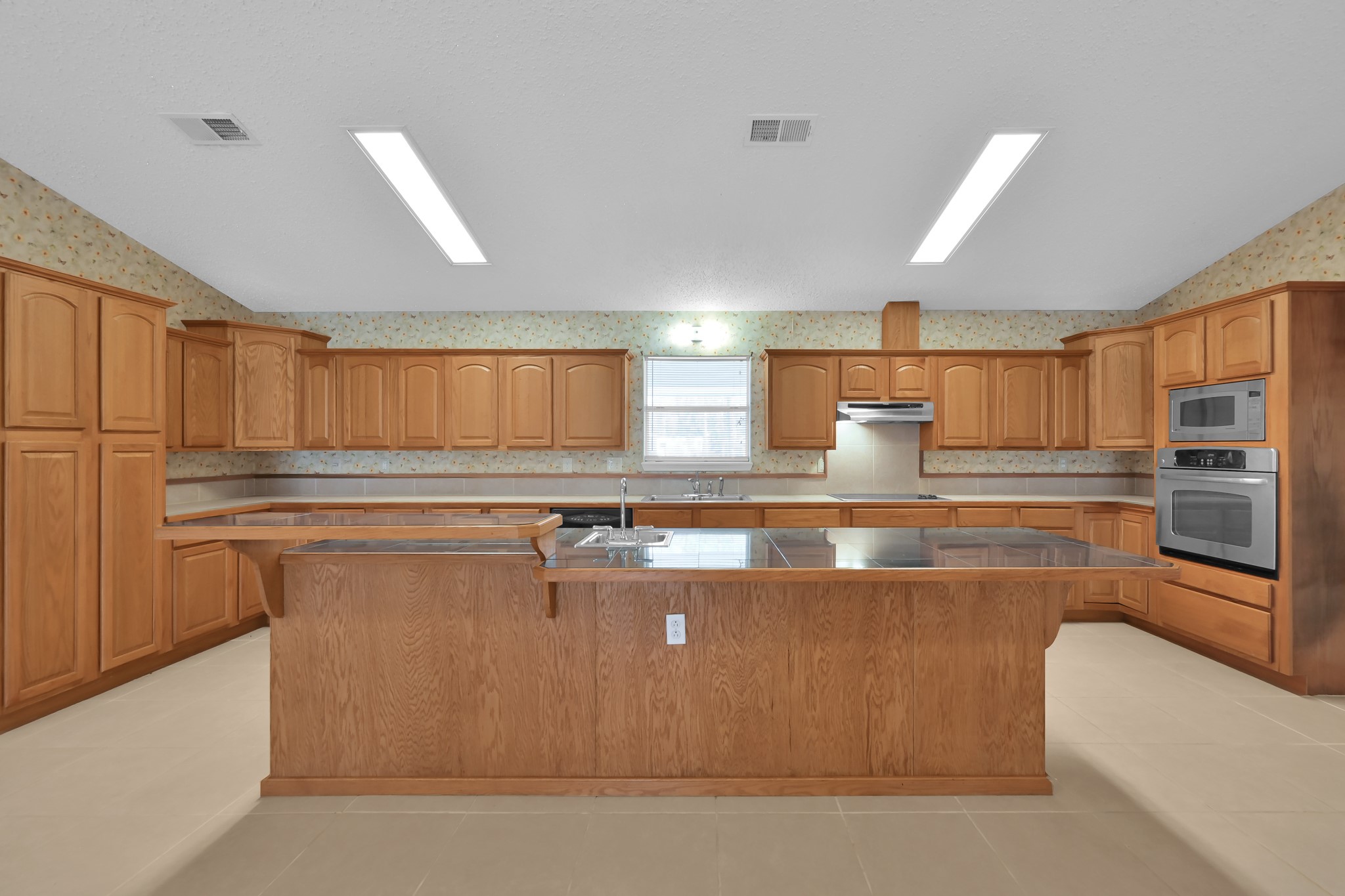 121 Magnolia Boulevard New Caney, TX 77357 - Photo 12 of 39 a kitchen with stainless steel appliances granite countertop a stove a sink and a refrigerator