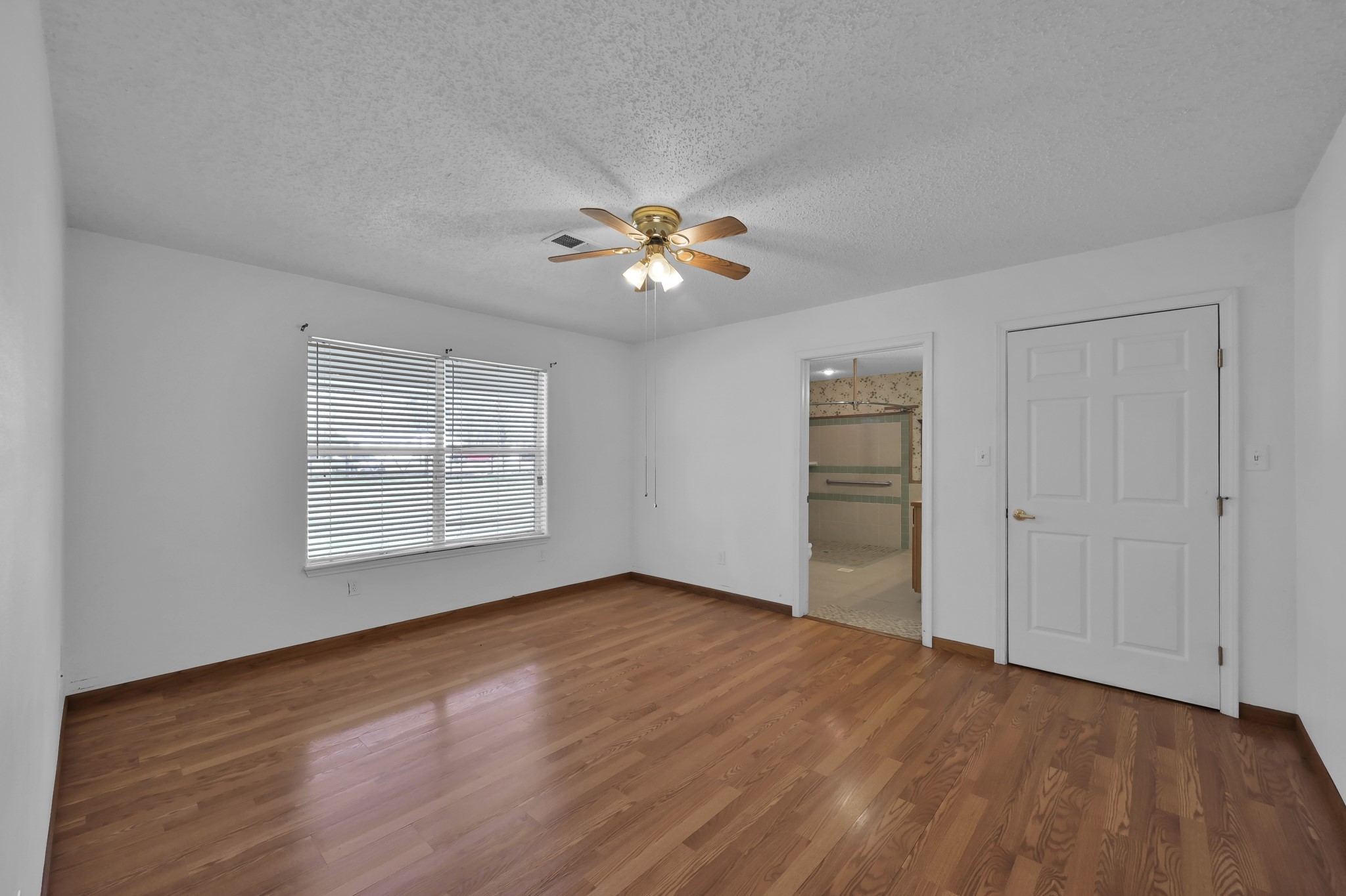 121 Magnolia Boulevard New Caney, TX 77357 - Photo 16 of 39 a view of an empty room with a window and wooden floor