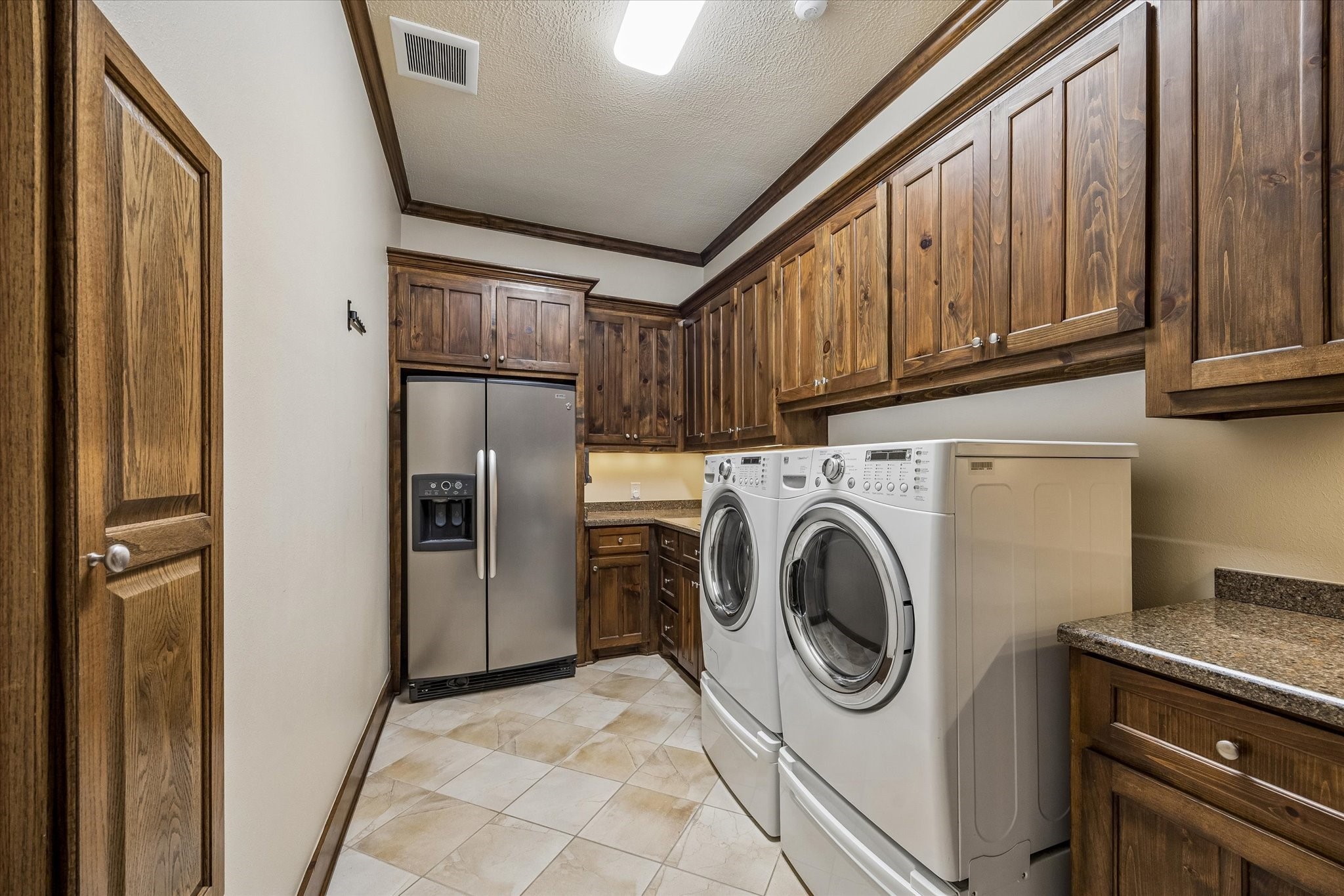 32102 Fulbrook Commons Fulshear, TX 77441 - Photo 31 of 50 Designed with efficiency in mind, the spacious laundry room offers extensive cabinetry, countertop workspace, and room for additional storage.