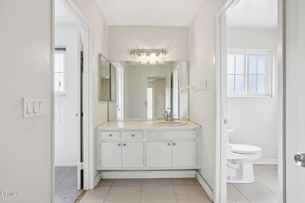 10856 Topeka Drive Porter Ranch, CA 91326 - Photo 23 of 40 a bathroom with a toilet a sink and mirror