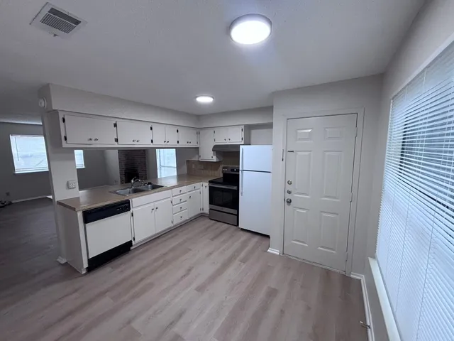 a kitchen with stainless steel appliances a refrigerator and a stove top oven