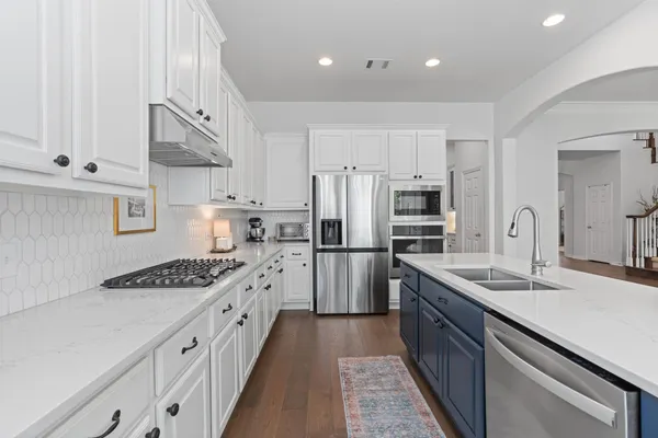a kitchen with stainless steel appliances granite countertop a sink stove and refrigerator