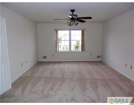 24 Lexington Road Monmouth Junction, NJ 08852 - Photo 17 of 21 an empty room with a chandelier fan and windows