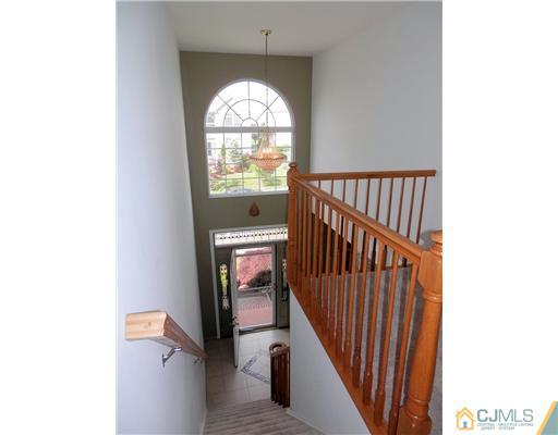 24 Lexington Road Monmouth Junction, NJ 08852 - Photo 3 of 21 a view of a hallway to a livingroom with wooden floor and a window