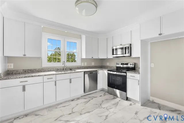 a kitchen with granite countertop a sink stainless steel appliances and cabinets