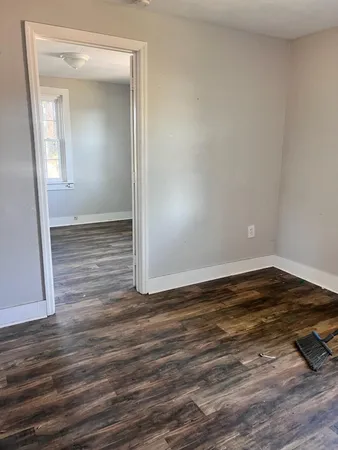a view of a room with wooden floor and white walls