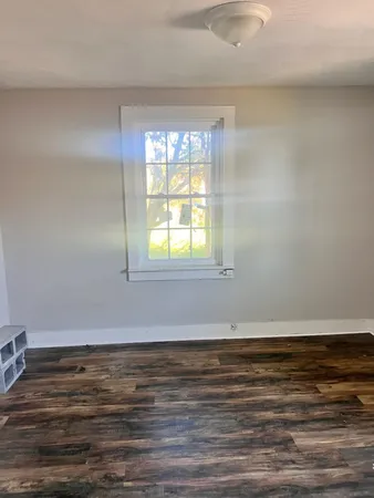 a view of a room with wooden floor and a window