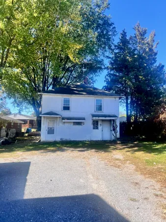 a view of a house with a yard and large tree