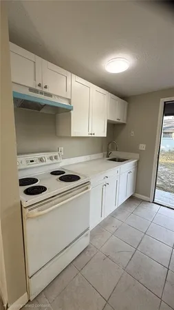 a kitchen with granite countertop a sink and a stove top oven