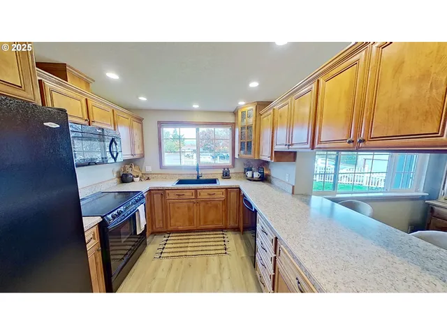 a kitchen with stainless steel appliances kitchen island granite countertop a sink stove and cabinets