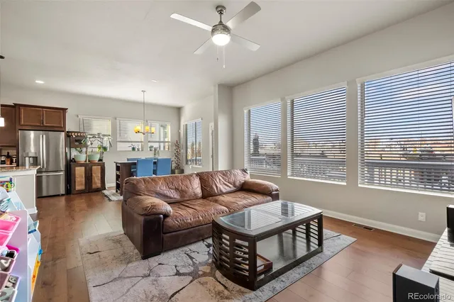 a living room with furniture and a large window with kitchen view