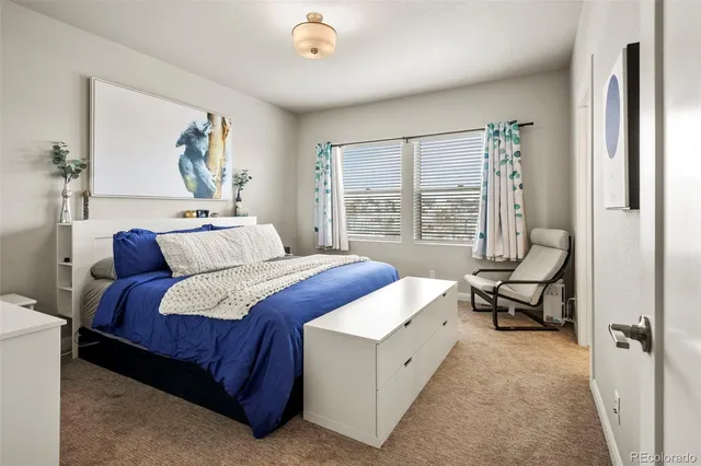 a bedroom with a bed and a large window