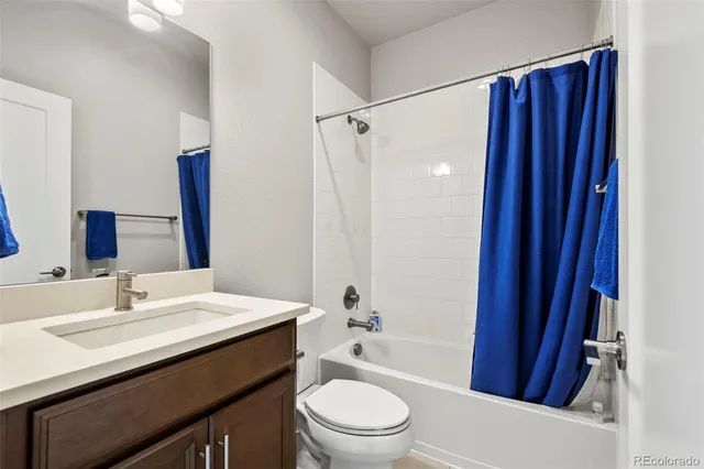 a bathroom with a sink a toilet a tub and shower