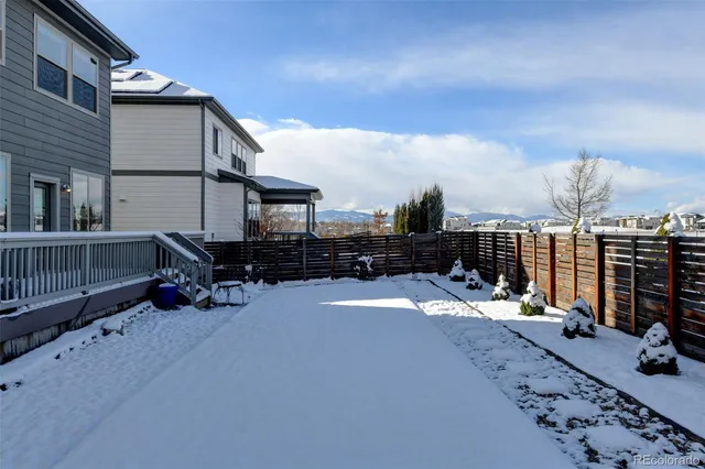a view of a dry yard with wooden fence