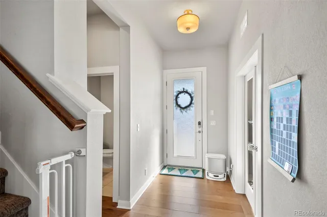 a view of a hallway with wooden floor and staircase