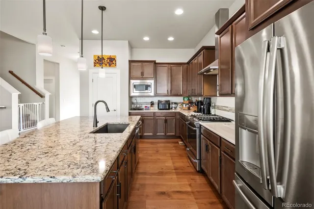 a large kitchen with stainless steel appliances granite countertop a sink a counter space and stainless steel appliances