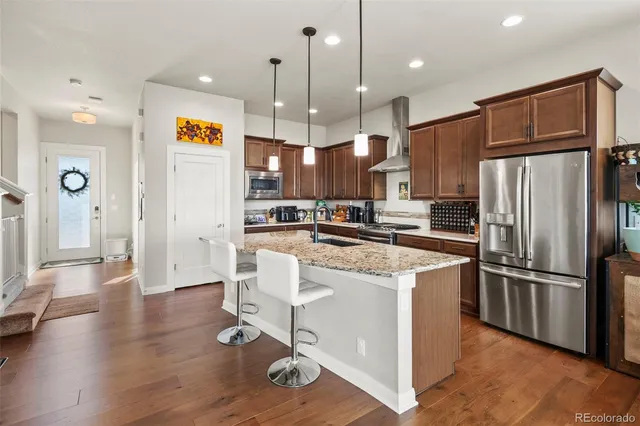 a kitchen with stainless steel appliances granite countertop a refrigerator a oven a sink and a refrigerator