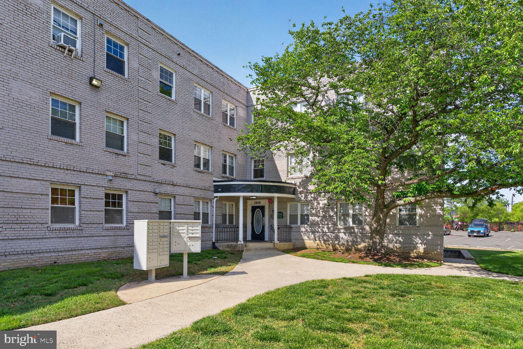 3868 9th Street Southeast, Unit 301 Washington, DC 20032 - Photo 1 of 16 a front view of a house with a yard and shrubs