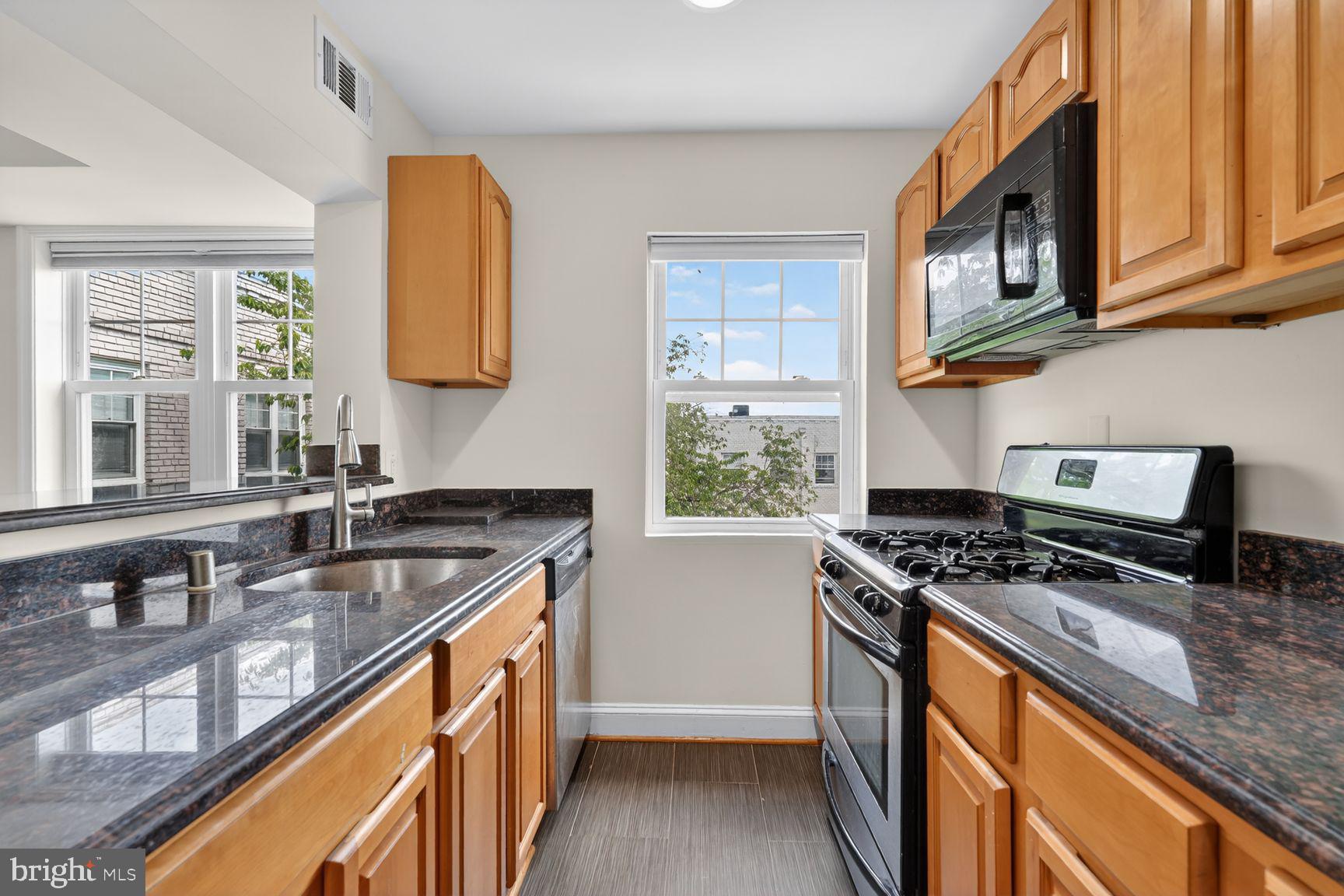 3868 9th Street Southeast, Unit 301 Washington, DC 20032 - Photo 2 of 16 a kitchen with stainless steel appliances granite countertop a sink stove and cabinets