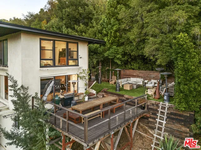 a view of a patio with table and chairs with wooden floor and fence