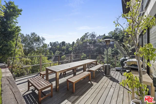 a view of a balcony with wooden floor and outdoor seating