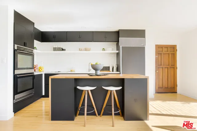 a kitchen with a sink a refrigerator and cabinets