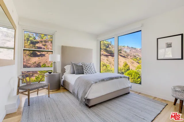 a bedroom with a bed and a painting on the wall