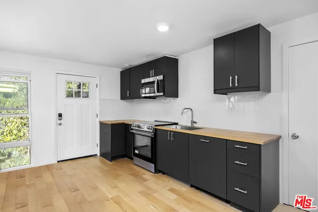 a kitchen with stainless steel appliances granite countertop a sink and a microwave