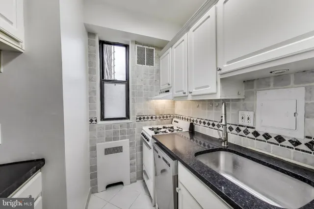 a kitchen with granite countertop a sink stove and cabinets