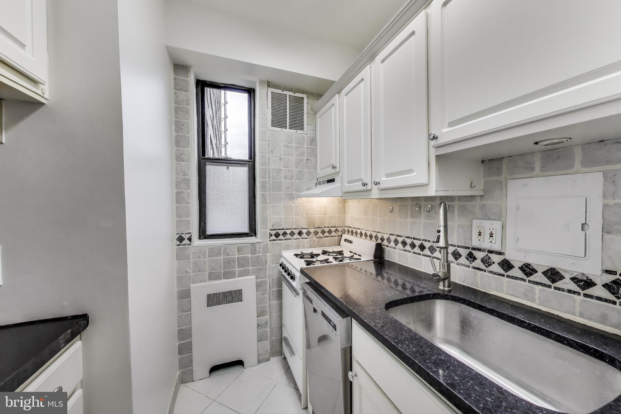 1 Scott Circle Northwest, Unit 121 Washington, DC 20036 - Photo 7 of 30 a kitchen with granite countertop a sink stove and cabinets