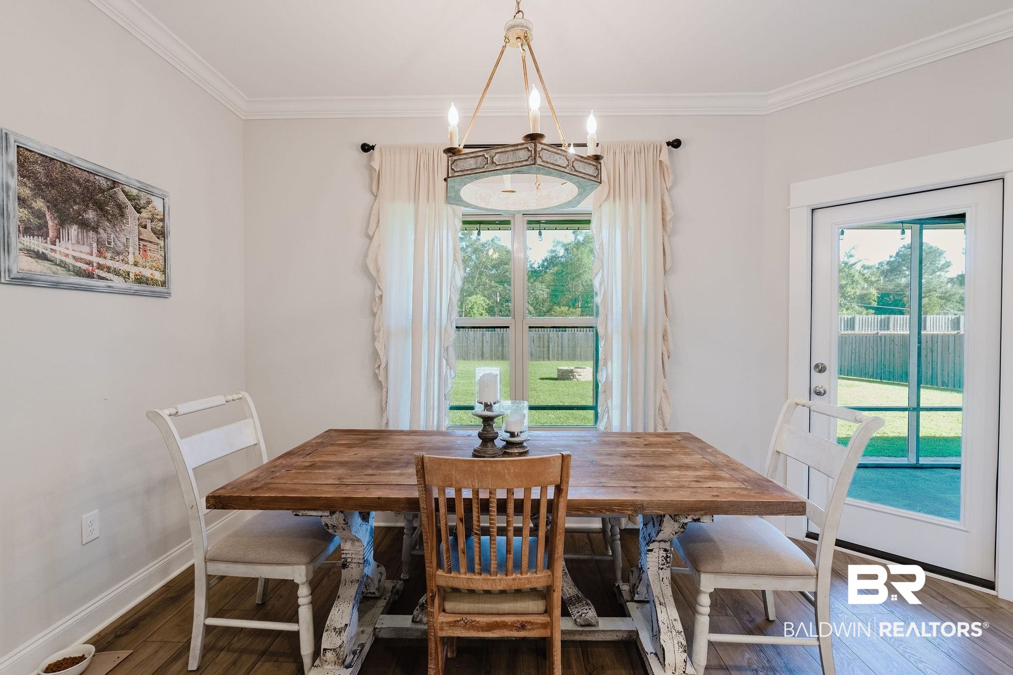 7872 Calverton Street Foley, AL 36535 - Photo 41 of 76 Dining area featuring wood-finish flooring, a multi-pane window with backyard views, crown molding, and a chandelier light fixture
