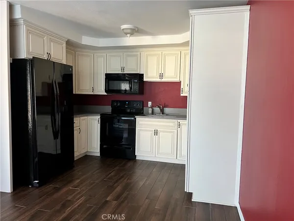 a kitchen with a refrigerator sink and cabinets