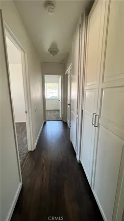 a view of a hallway with wooden floor and stairs
