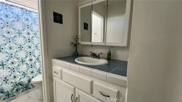 a bathroom with a granite countertop sink and a mirror