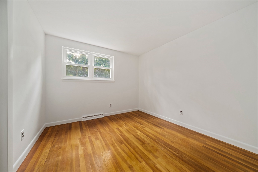 12 Tall Tree Road Sharon, MA 02067 - Photo 12 of 26 an empty room with a window and wooden floor