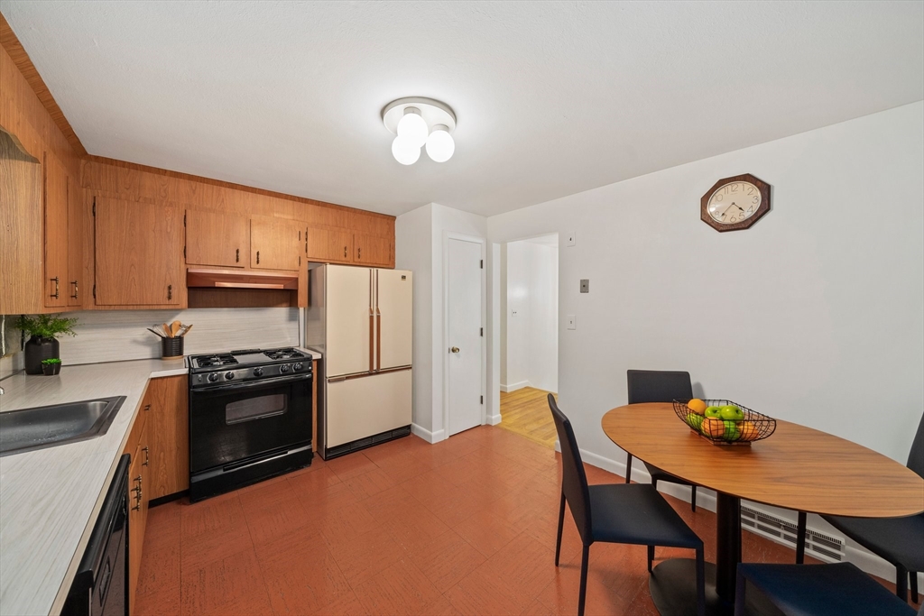 12 Tall Tree Road Sharon, MA 02067 - Photo 8 of 26 a kitchen with stainless steel appliances wooden floor dining table and chairs