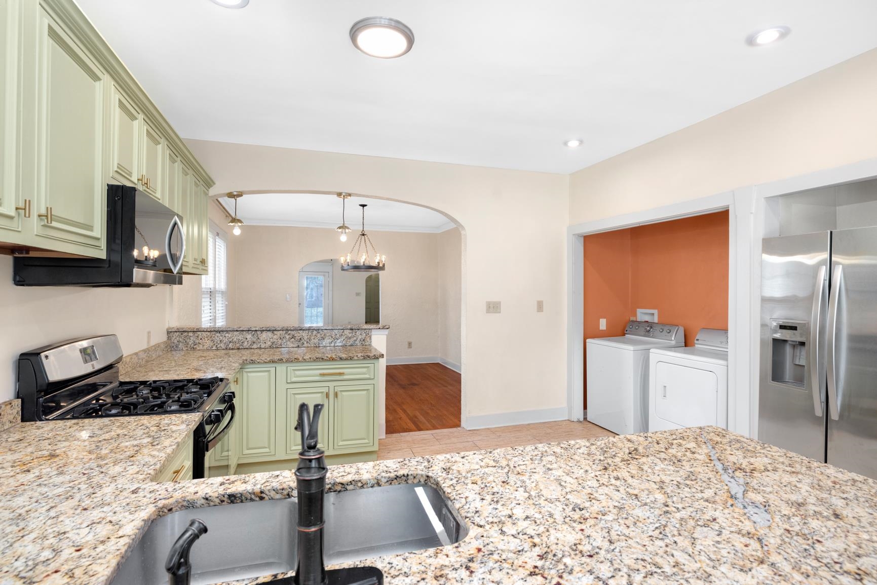 331 Alexander Street Memphis, TN 38111 - Photo 15 of 25 Kitchen with stainless steel appliances, washing machine and dryer, light stone counters, and green cabinetry