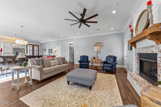 a view of a dining room and livingroom with furniture wooden floor a rug a chandelier