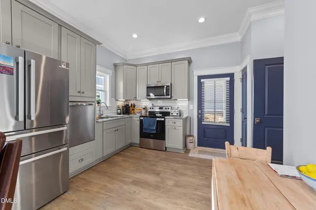 an aerial view of a house with swimming pool and large trees