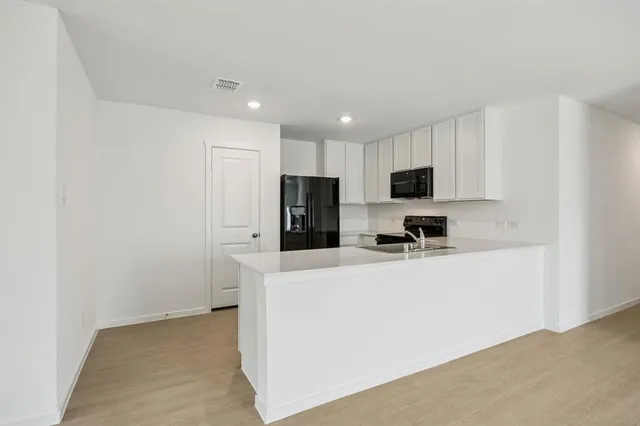 a view of kitchen with stainless steel appliances refrigerator sink and microwave