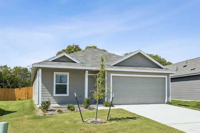a front view of a house with a yard and potted plants
