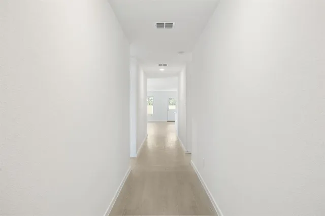 a view of a hallway with wooden floor