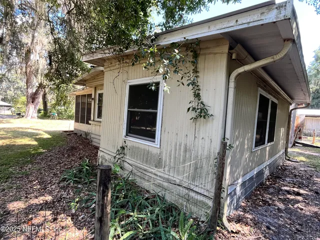 a view of a house with a door and wooden fence