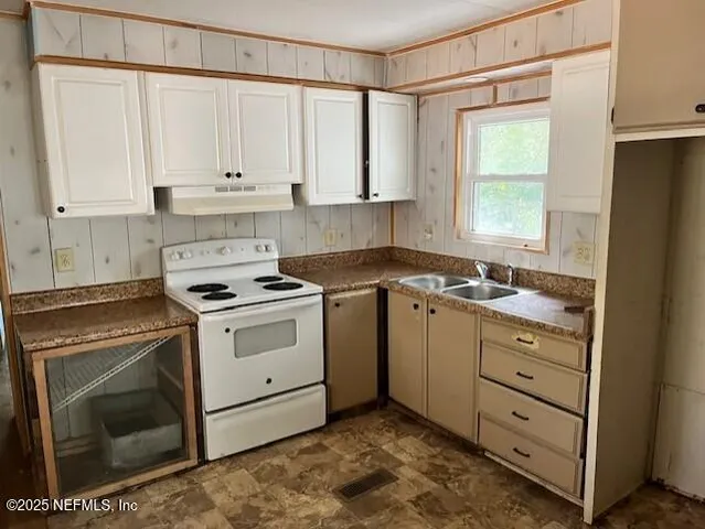 a white stove top oven sitting inside of a kitchen